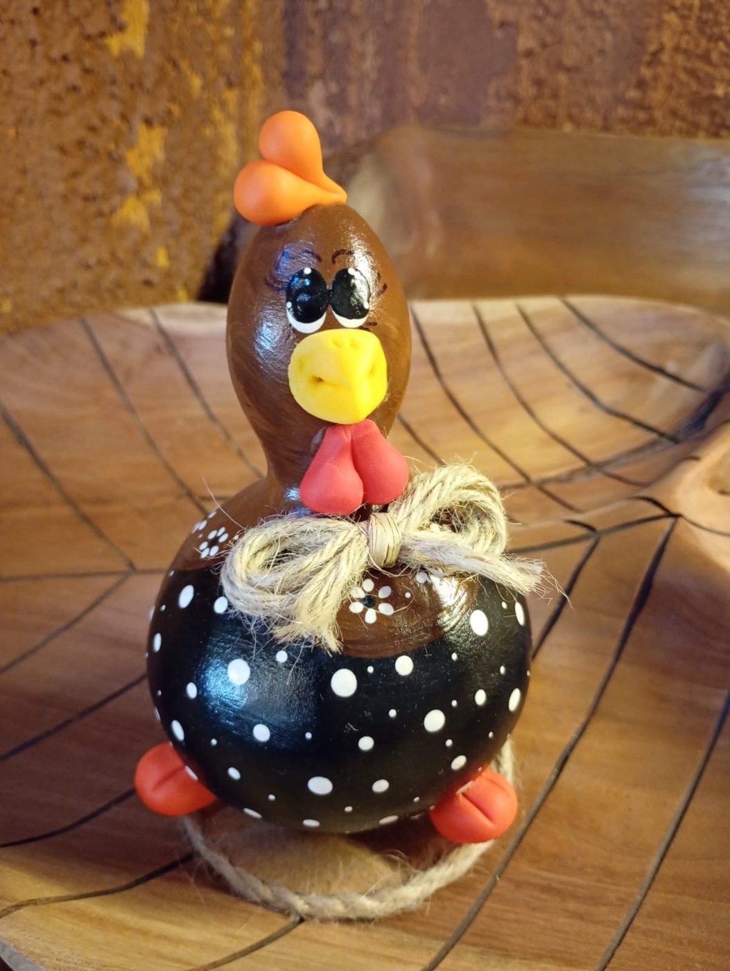 Galinha de Angola em cabaça, pintada em preto com bolinhas brancas e crista laranja