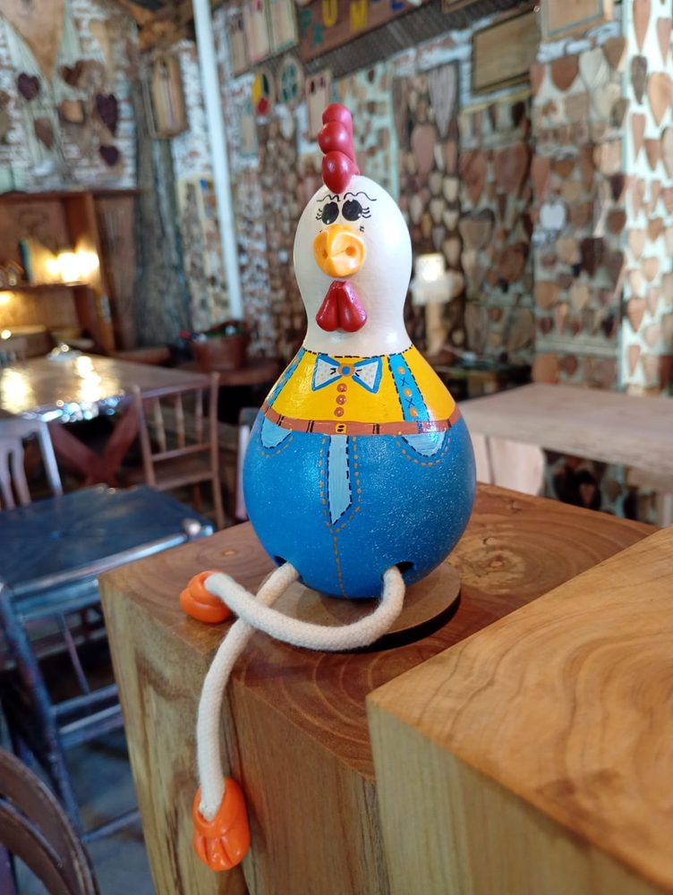 Galinha de cabaça com pernas de cordão, macacão azul e amarelo
