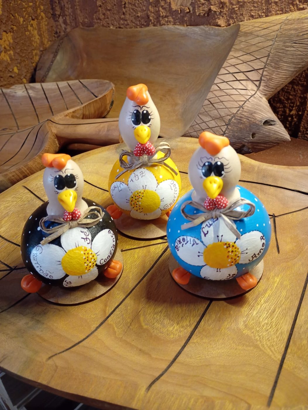 Trio de galinhas decorativas de cabaça em preto, amarelo e azul, com flores e palavras como Paz, Amor e Confiança